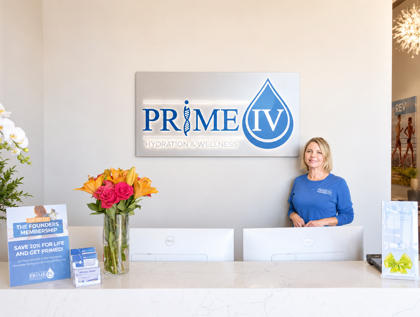 Ann, RN, owner of Prime IV Hydration & Wellness, standing at the front desk beneath the Prime IV logo